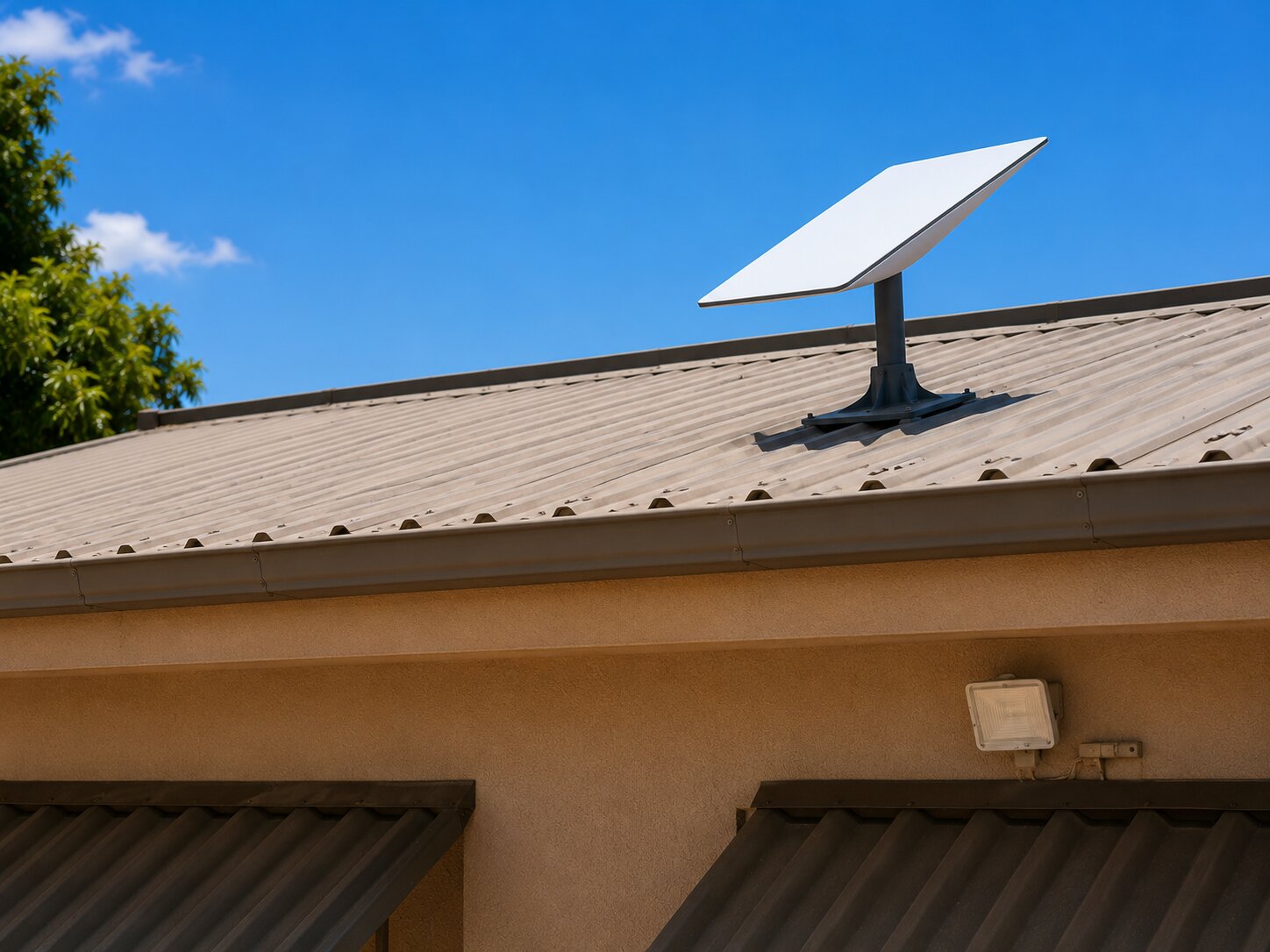 Starlink satellite dish mounted on the metal roof of the Starbridge academy in Tete under a clear blue sky